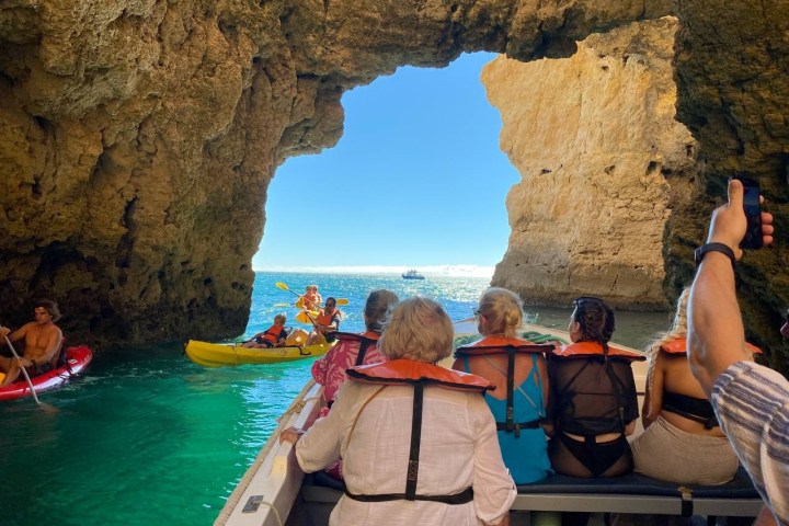 a group of people sitting on a rock next to water